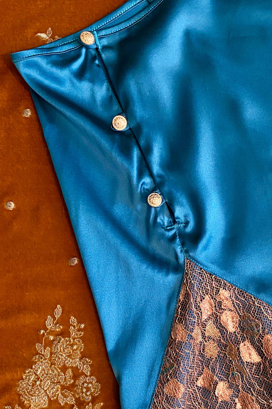Button detail on blue silk tap pants with gold lace insert