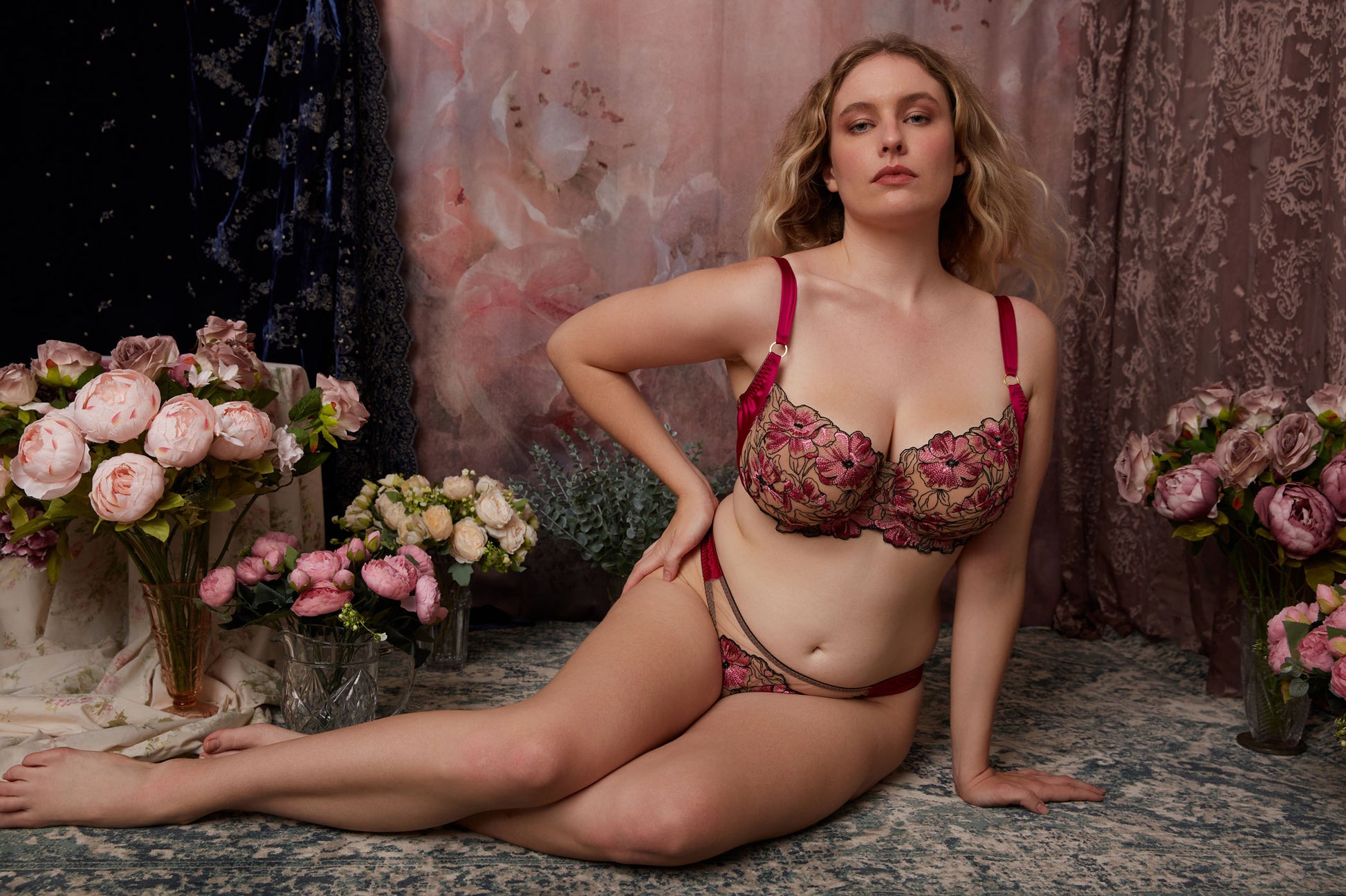 Romantic shot of pink and black embroidery and silk lingerie set with DD+ cup bra, with background of pink roses and blue velvet
