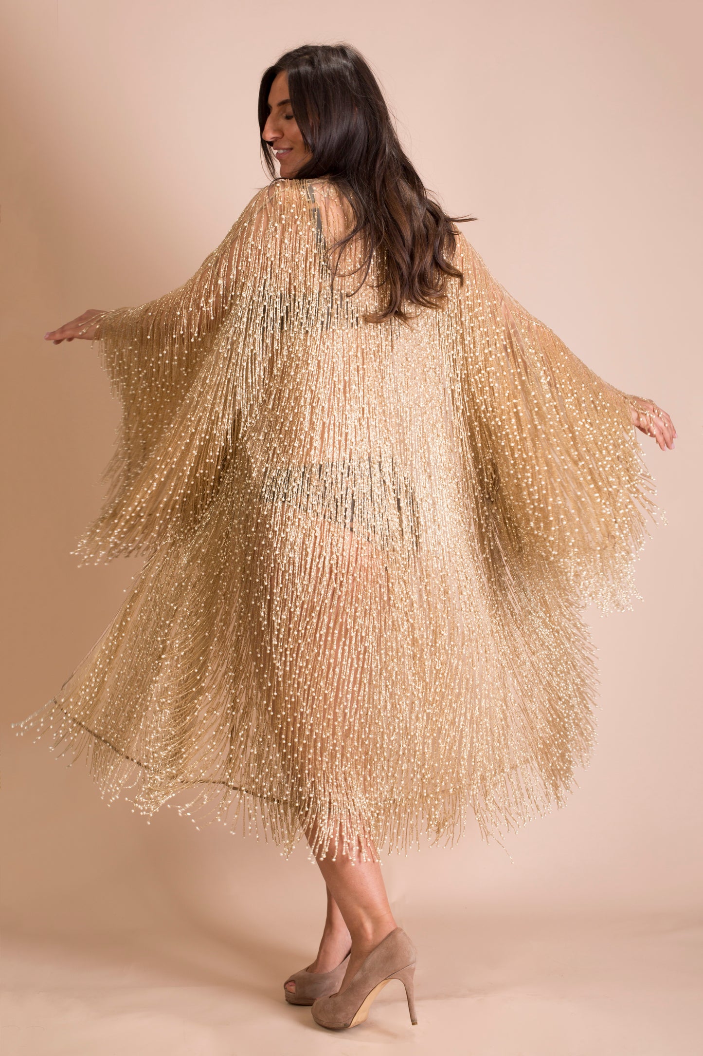 Robe covered in gold and pearl beaded strands spinning around