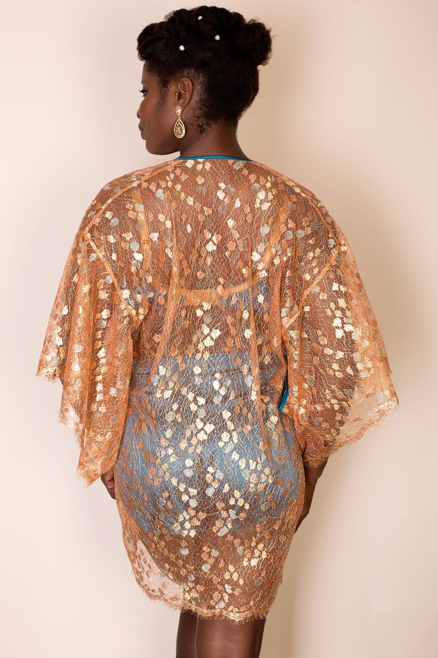 Back view sheer gold lace robe worn open with blue silk tap pants under