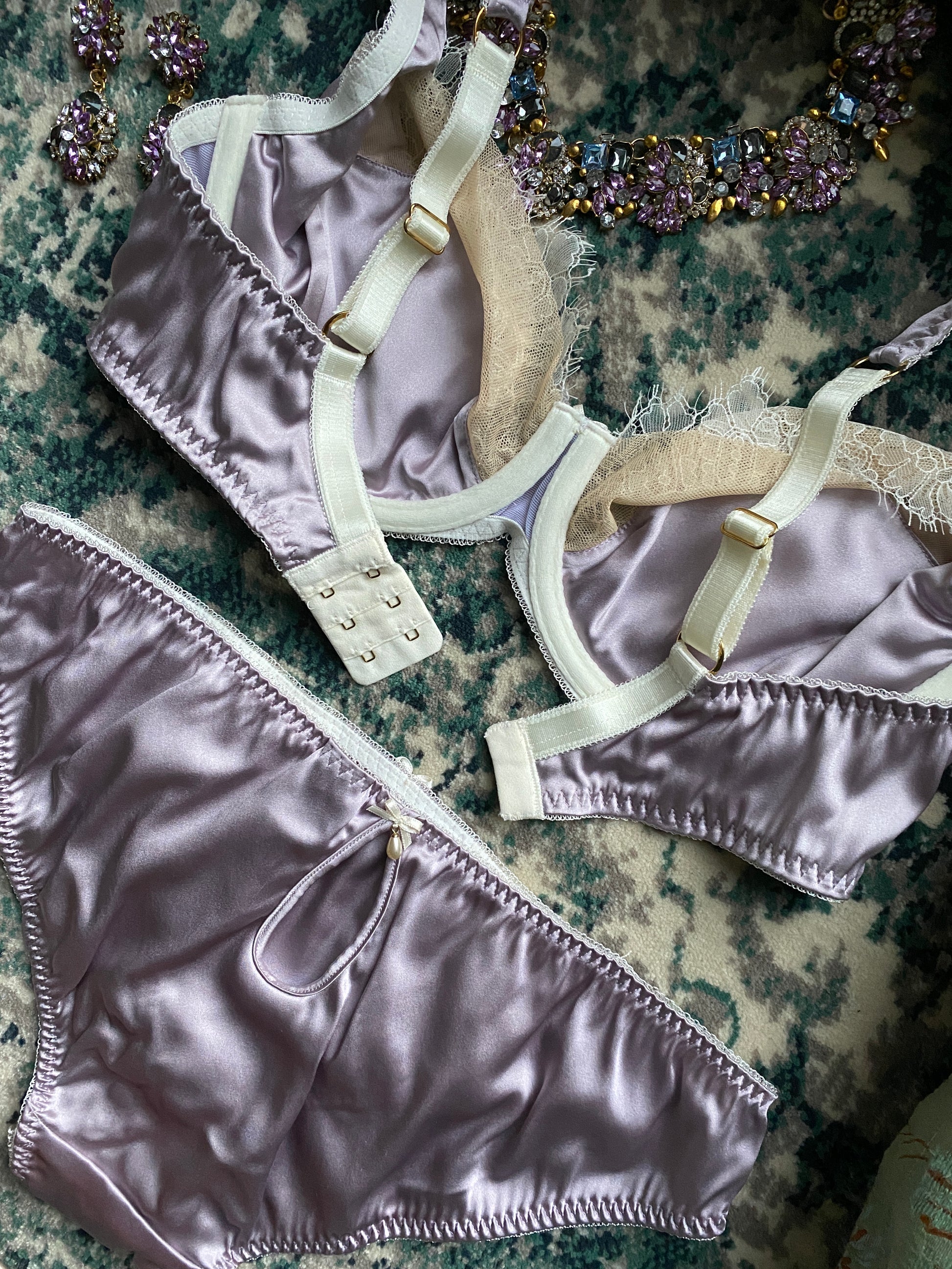 Flatlay detail of silk linings in bra cup and back keyhole pearl on panty