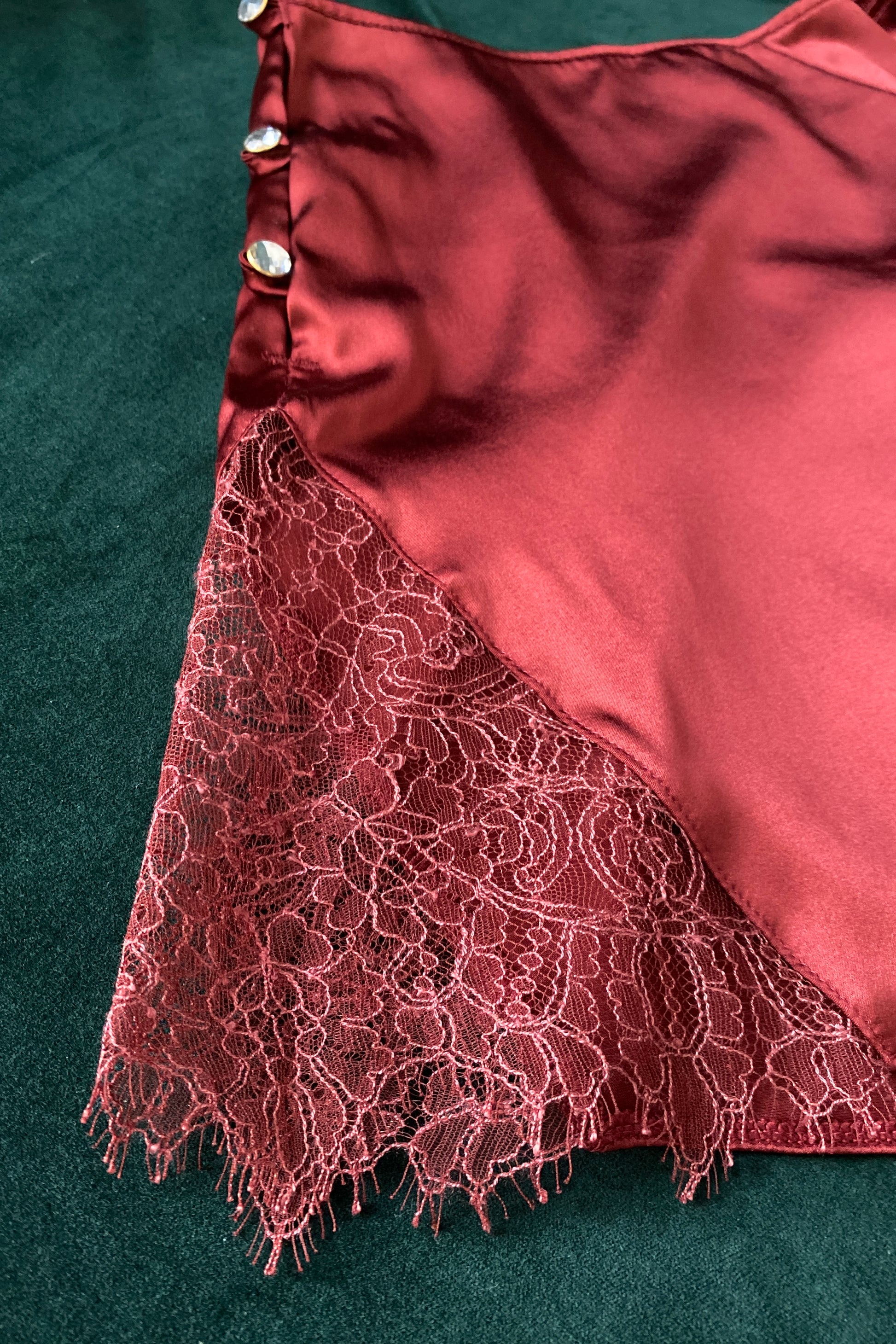 Detail of dark red French lace insert on red silk tap pants with crystal buttons